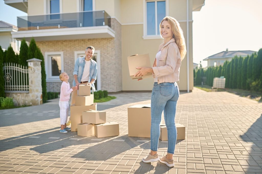 Family moving to new home in Belmont, NC carrying boxes on moving day